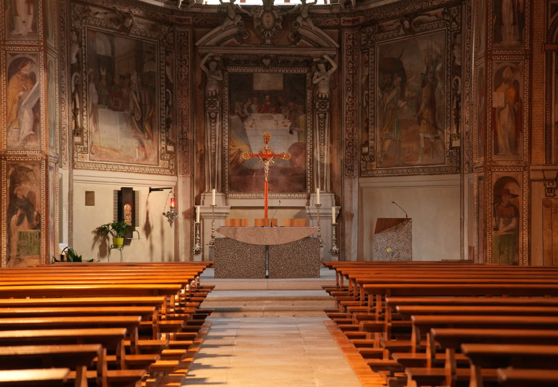 Interno di una chiesa della Valle di Blenio, con banchi, altare e pareti affrescate